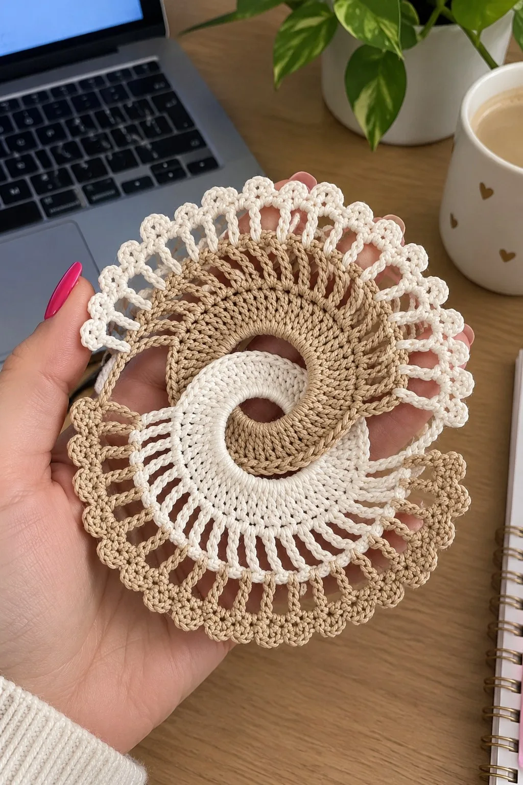 Cream and warm tan crochet spiral doily with tall chain bars and scalloped picot edge on a wooden table