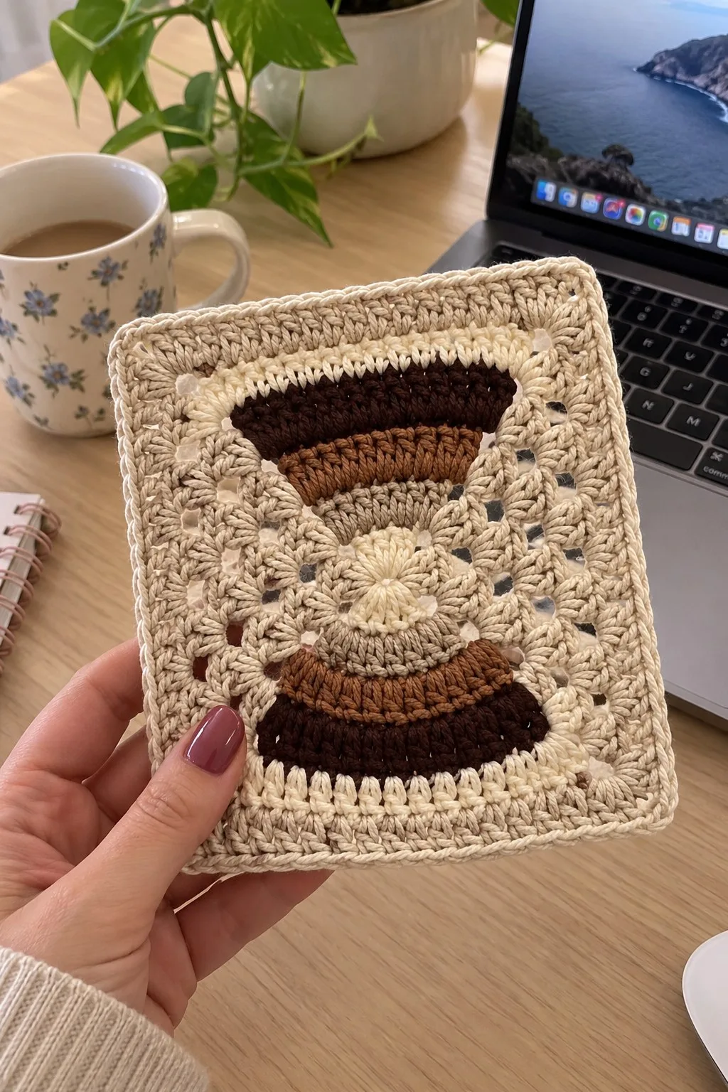 Neutral cream crochet square with stacked brown semicircles and lacy granny-style background, edged with a tidy rope border