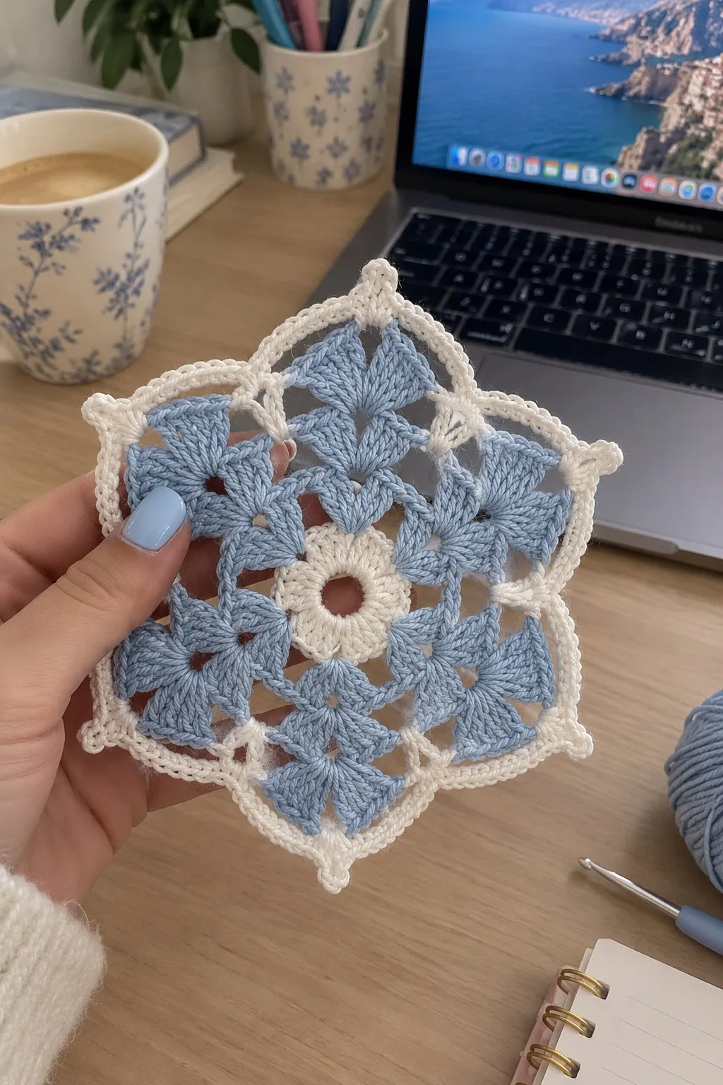 Ice blue and cream crocheted snowflake medallion with six pointed scalloped arms and picot tips